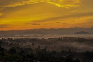 Golden-hour view of Cheengeri Hill, Wayanad, with misty valleys and hills, reflecting the recovery after the July 2024 landslide.